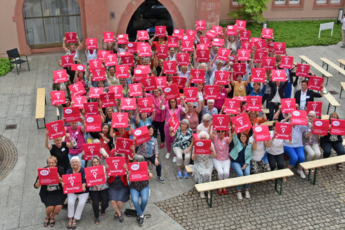 kfd-Frauen halten Sitzkissen hoch